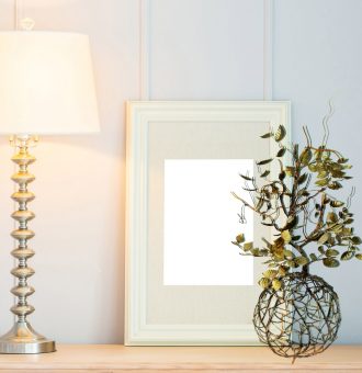 Blank frame with light lamp decoration on table